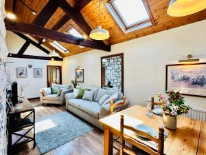 a living room with a couch and a table at The Old Mill Holiday Cottages, Nr Mold in Mold