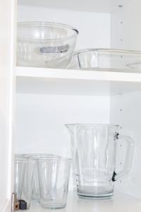 a shelf with clear glass bowls on it at Cosy house in West Yorkshire in Batley