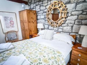 um quarto com uma cama e uma parede de pedra em The Old Mill Holiday Cottages, Nr Mold em Mold
