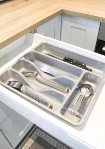 a kitchen sink with utensils in a drawer at Cosy house in West Yorkshire in Batley