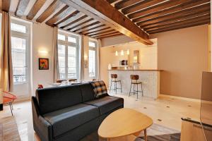 a living room with a couch and a kitchen at Elegant 2BDR 6P Apartment in the Heart of the 5th Arrondissementt in Paris