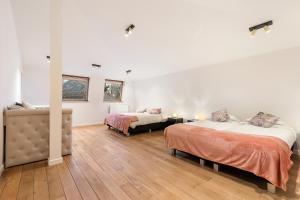 a white room with two beds and a mirror at WijnKasteel Haksberg in Tielt