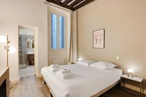 - une chambre avec un grand lit blanc et des serviettes dans l'établissement Elegant 2BDR 6P Apartment in the Heart of the 5th Arrondissementt, à Paris