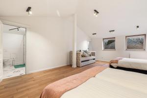 a white bedroom with two beds and a bathroom at WijnKasteel Haksberg in Tielt +47 photos