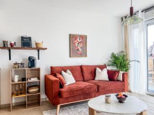 uma sala de estar com um sofá vermelho e uma mesa em Charmant Cocon Nature Toulouse em Toulouse