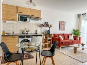 圖盧茲的住宿－Charmant Cocon Nature Toulouse，厨房以及带桌椅的起居室。