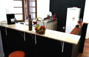 eine Küchentheke mit einem Korb mit Obst und Weingläsern in der Unterkunft Casa antiga, linda ótima localização prox ao shopping in Porto Alegre