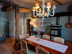 a dining room with a table and a chandelier at Gutshaus De La Fontaine in Feilsdorf