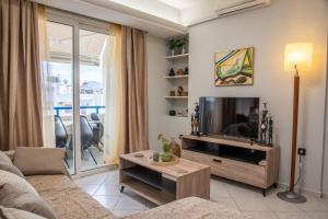 a living room with a couch and a television at Sky 7 View Apartment in Heraklion