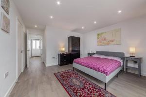 a bedroom with a bed and a desk and a rug at Amazing 2 Bed Bath Flat with London Eye View LM7 in London