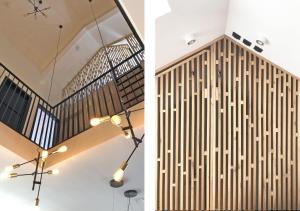 a staircase with a wood paneled wall and a chandelier at Bramendijk in Groede