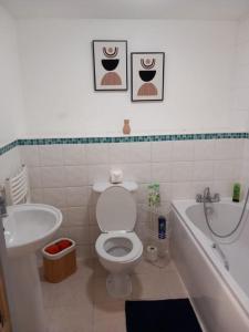 a bathroom with a toilet and a tub and a sink at Broad street - Balcony 1 bedroom apartment in Birmingham