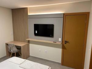 una camera con TV a parete e porta di Loft Solaris Apart Hotel - Suíte - Apt N104 a João Câmara