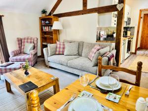 a living room with a couch and a table at The Old Mill Holiday Cottages, Nr Mold in Mold