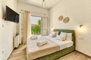a bedroom with a large bed with a large window at Villa Agricola in Alykes
