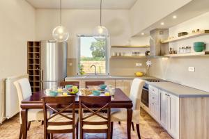a kitchen with a table and chairs and a kitchen with a sink at Villa Agricola in Alykes