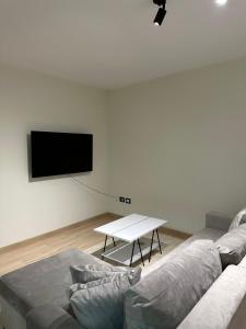 - un salon avec un canapé et une télévision murale dans l'établissement White apartment, in the center of Tirana, à Tirana