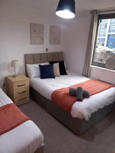 a bedroom with two beds and a window at Broad street - Balcony 1 bedroom apartment in Birmingham