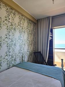 1 dormitorio con 1 cama y papel pintado con motivos florales en Sunrise Beach Apartment en Póvoa de Varzim