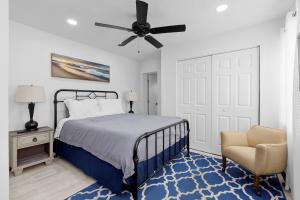 une chambre avec un lit avec un ventilateur de plafond et une chaise dans l'établissement Summer Retreat House, à Fort Lauderdale