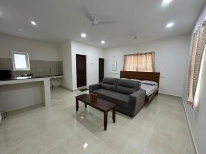 a living room with a couch and a table at SAIBALA HOMESTAY - AC 1 BHK STUDIO NEAR AlRPORT in Chennai