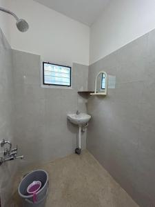 uma casa de banho com um lavatório, um WC e uma janela. em HOMESTAY - AC 1 BHK STUDIO NEAR AlRPORT em Chennai