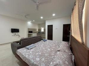 a bedroom with a bed and a couch in it at SAIBALA HOMESTAY - AC 1 BHK STUDIO NEAR AlRPORT in Chennai