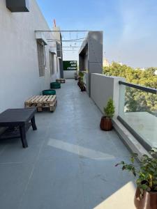 SihorHOTEL HARE KRISHNA的阳台,带桌子和长椅的建筑