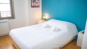 ein weißes Bett in einem Zimmer mit blauer Wand in der Unterkunft Les Rives du Clain - Sublime T4 au bord de l'eau in Poitiers
