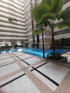 a swimming pool with a palm tree in a building at Grand Residence in Bangkok