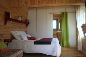 a bedroom with a bed and a green curtain at Chaledhote in Écurolles