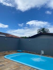 a large blue swimming pool on a patio at Casa d'Itapoá in Itapoa
