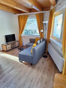 uma sala de estar com um sofá e uma televisão em Haus Edelweiss Mölltal em Flattach