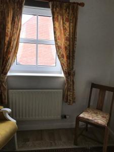 une fenêtre avec un radiateur et une chaise dans un dortoir dans l'établissement 18 Wixon Path, à Buckinghamshire