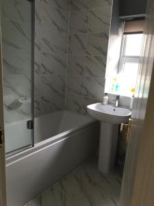 a bathroom with a tub and a sink and a shower at 18 Wixon Path in Buckinghamshire