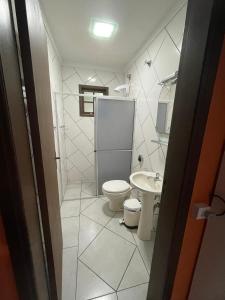 a bathroom with a toilet and a sink at Casa d'Itapoá in Itapoa +8 photos
