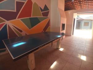 a ping pong table in a room with a wall at Casa d'Itapoá in Itapoa