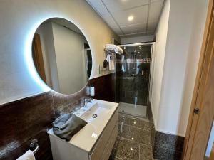 y baño con lavabo, espejo y ducha. en Antídoto Rooms Zocodover, en Toledo