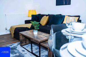 uma sala de estar com um sofá preto e uma mesa em 2ndHomeStays -Walsall- Charming 3-Bedroom House em Walsall