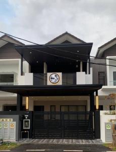 a black and white building with a clock on it at [New Double Storey] 12 to 14 Pax - SG ABONG - BRIGHT INN HOMESTAY in Muar