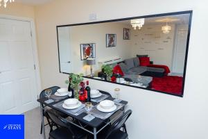 a dining room with a table and a large mirror at 2ndHomeStays-West Bromwich- 2-Bedroom Maisonette in West Bromwich