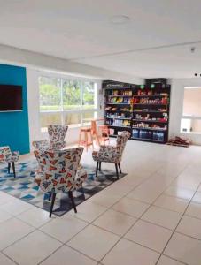 sala de estar con sillas, mesa y estanterías en Apartamento no Guarujá - Enseada, en Guarujá
