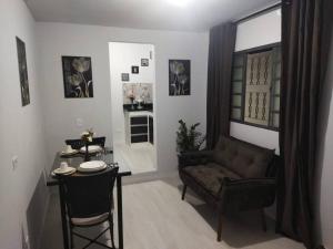 a living room with a couch and a table at Kitnet 1 - próximo ao centro de Jacareí in Jacareí