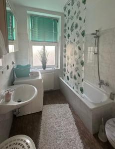 a bathroom with a sink and a tub and a toilet at Ferienwohnung am Elberadweg in Dessau