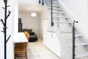 a white staircase in a living room with a table and chairs at "Peace & love house" en campagne de Poitiers in Montamisé