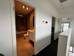 Baño blanco con aseo y lavamanos en Best Brisbane location to enjoy vocation, en Brisbane