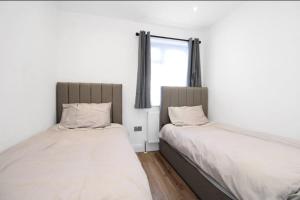 two beds sitting next to each other in a room at Stunning 2 bedroom in Luton ! in Luton
