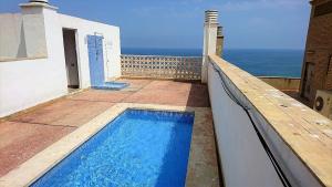una piscina en un balcón con el océano en el fondo en UNIQUE APT. W/POOL- ACROSS THE BEACH-WIFI-A/C, en Alicante