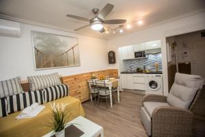 Una sala de estar con un sofá y una mesa y una cocina. en UNIQUE APT. W/POOL- ACROSS THE BEACH-WIFI-A/C, en Alicante