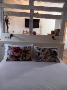 1 dormitorio con 1 cama blanca y 2 almohadas en Casa de las Lías, en Chinchón
